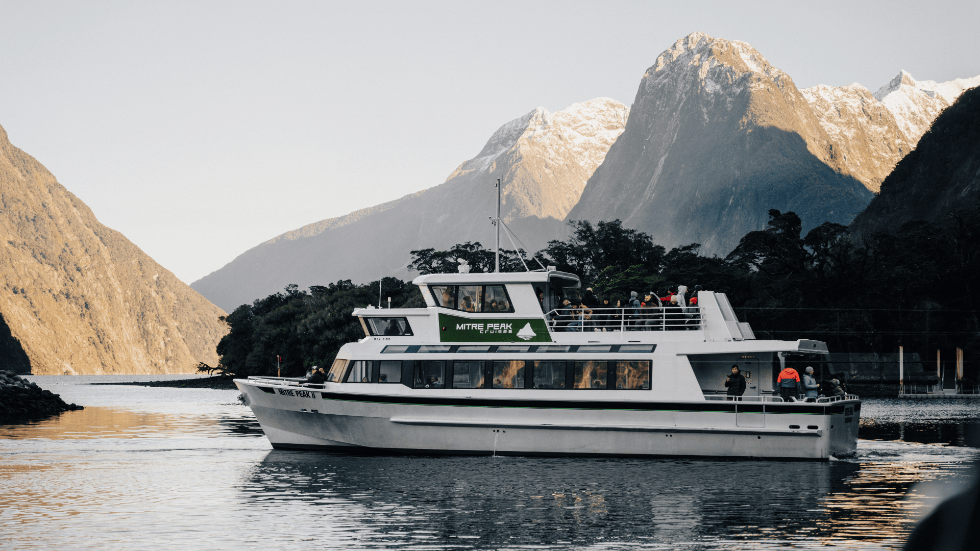 a small boat in a body of water with a mountain in the background