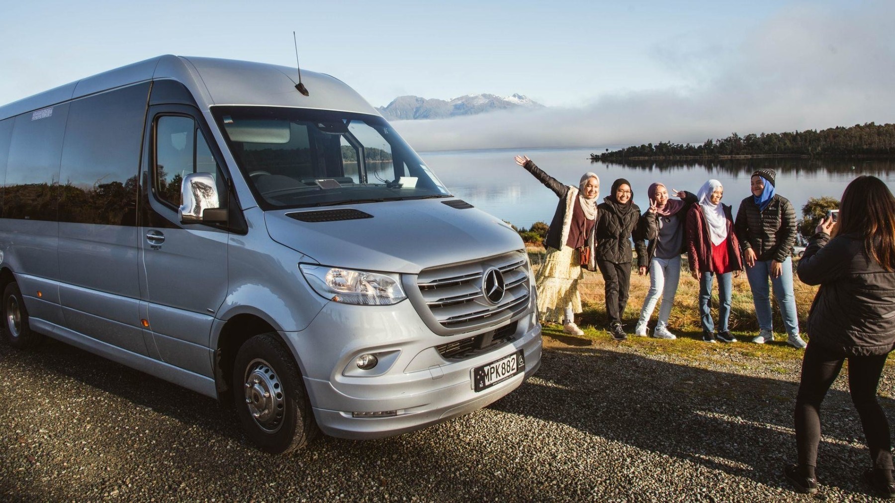 a group of people standing on top of a car