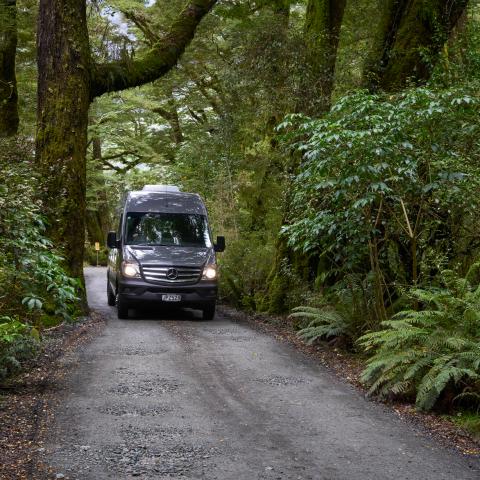 a bus traveling down a dirt road