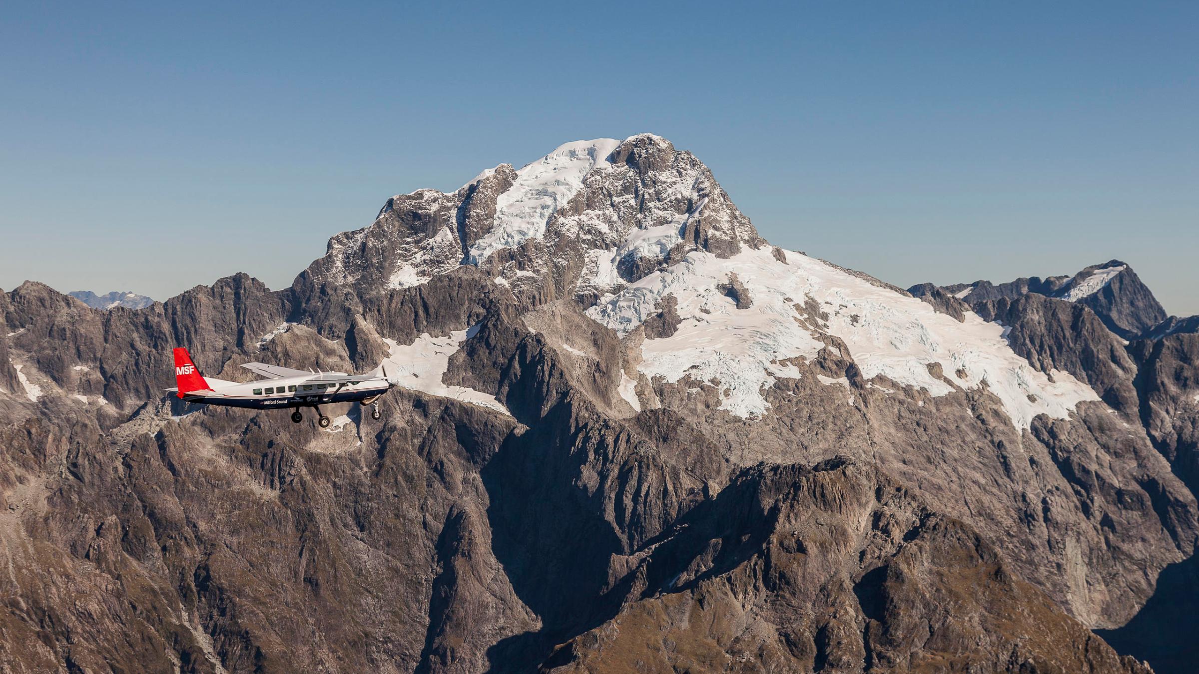 a man flying through the air on a snow covered mountain