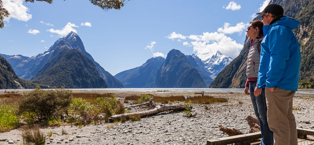 a man standing in front of Milford Sound