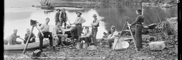 a group of people standing next to a body of water