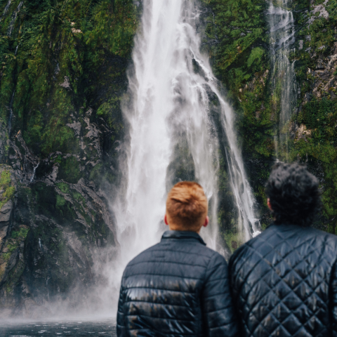 a man standing next to a waterfall