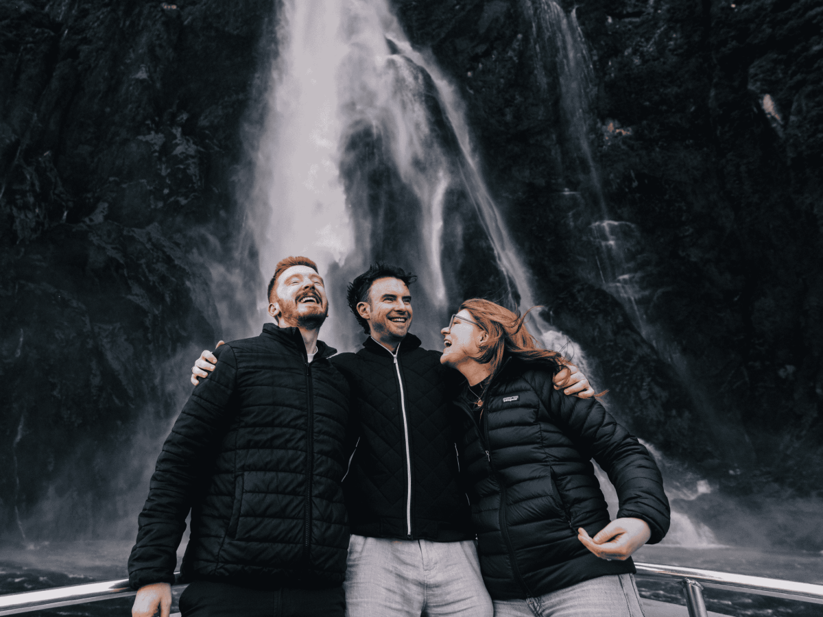 a man and a woman standing next to a waterfall